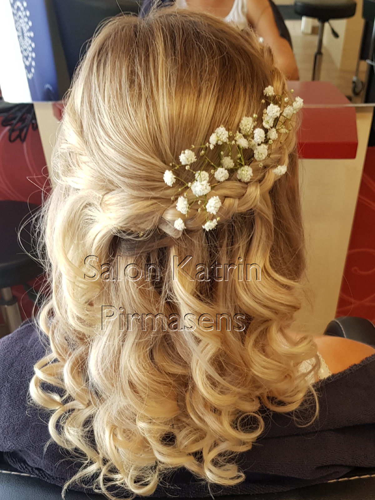 Halboffene Brautfrisur mit Locken und Blütenschmuck